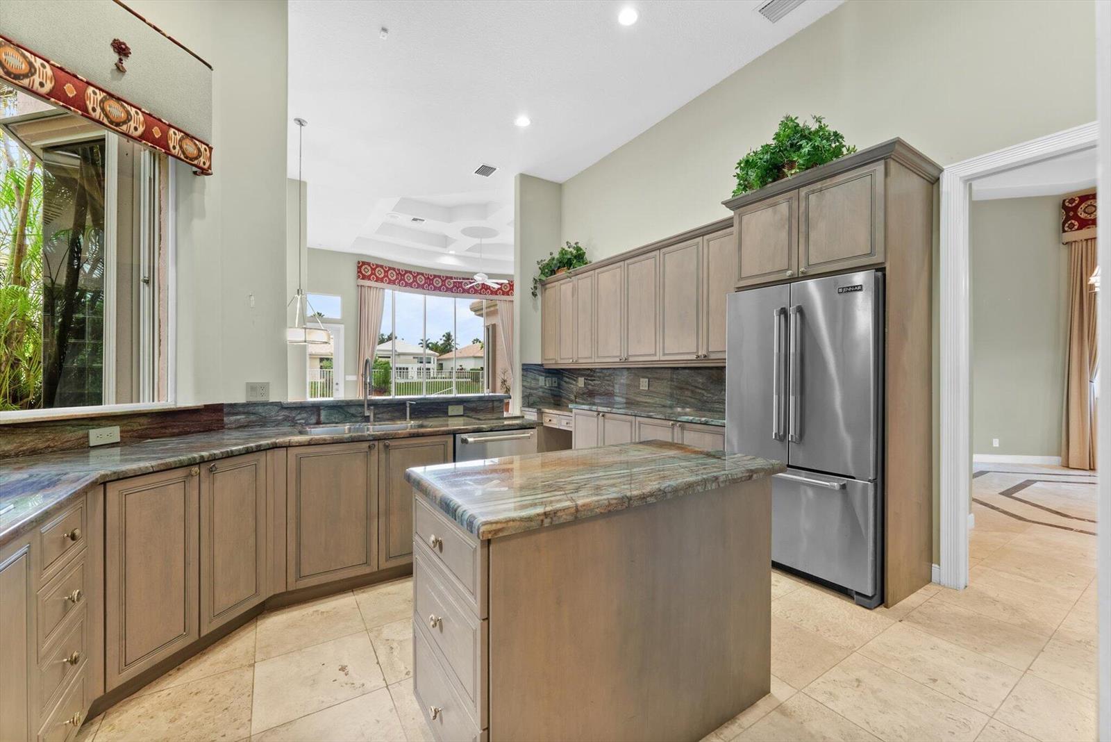 A kitchen features light wood cabinets, granite countertops, a center island, and stainless steel appliances — 7081 Mallorca Crescent, Boca Raton FL 33433, BOCA RATON, FL