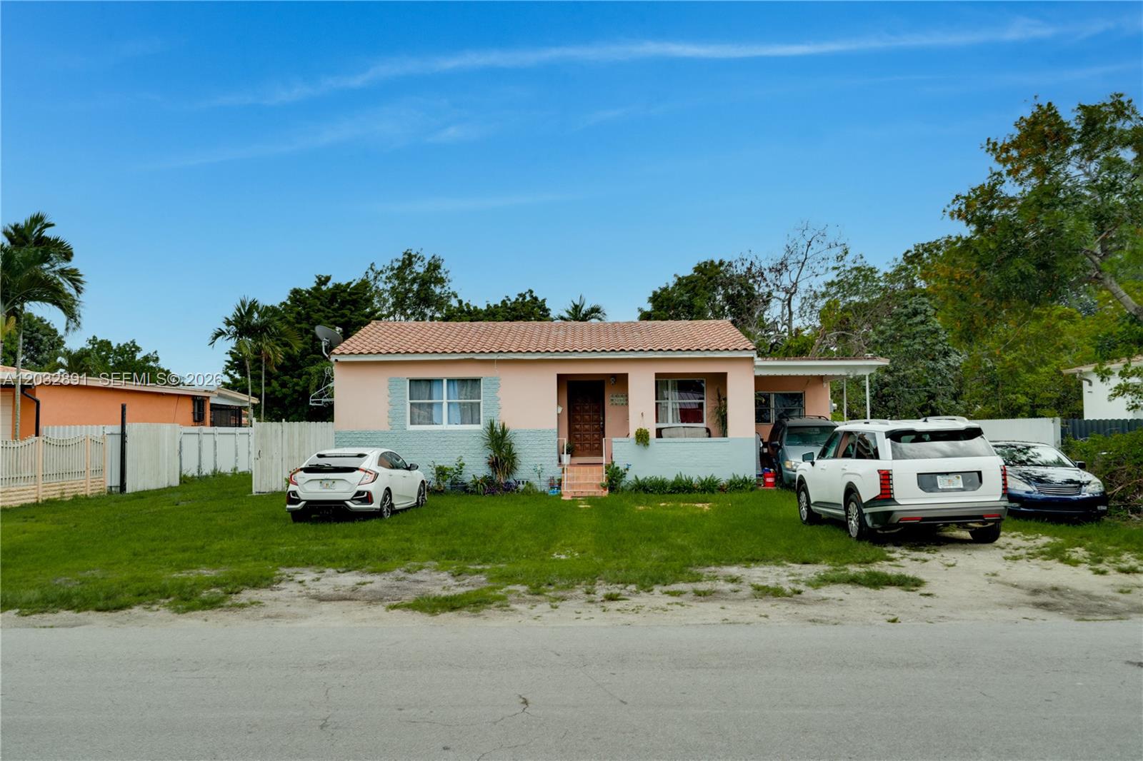 A single-story house with a peach and light blue exterior sits behind a grassy yard — 5860 SW 19th St, Miami FL 33155, MIAMI, FL