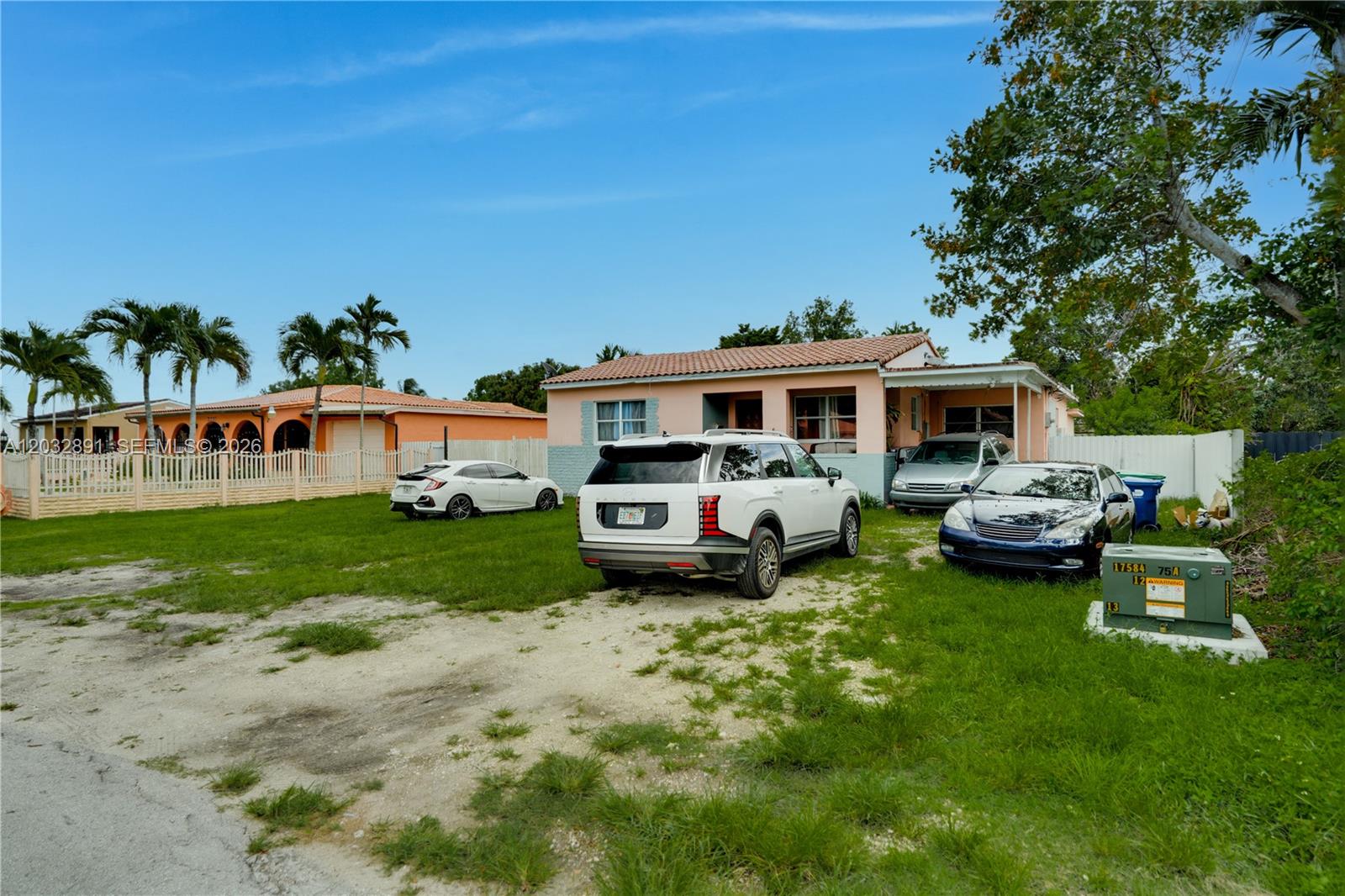 A single-story peach-colored house with three parked cars on a gravel and grass driveway — 5860 SW 19th St, Miami FL 33155, MIAMI, FL