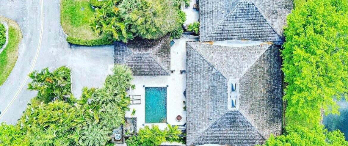 An aerial view shows a house with a shingled roof, a pool, and surrounding trees — 2107 Wightman Drive, Wellington FL 33414, WELLINGTON, FL
