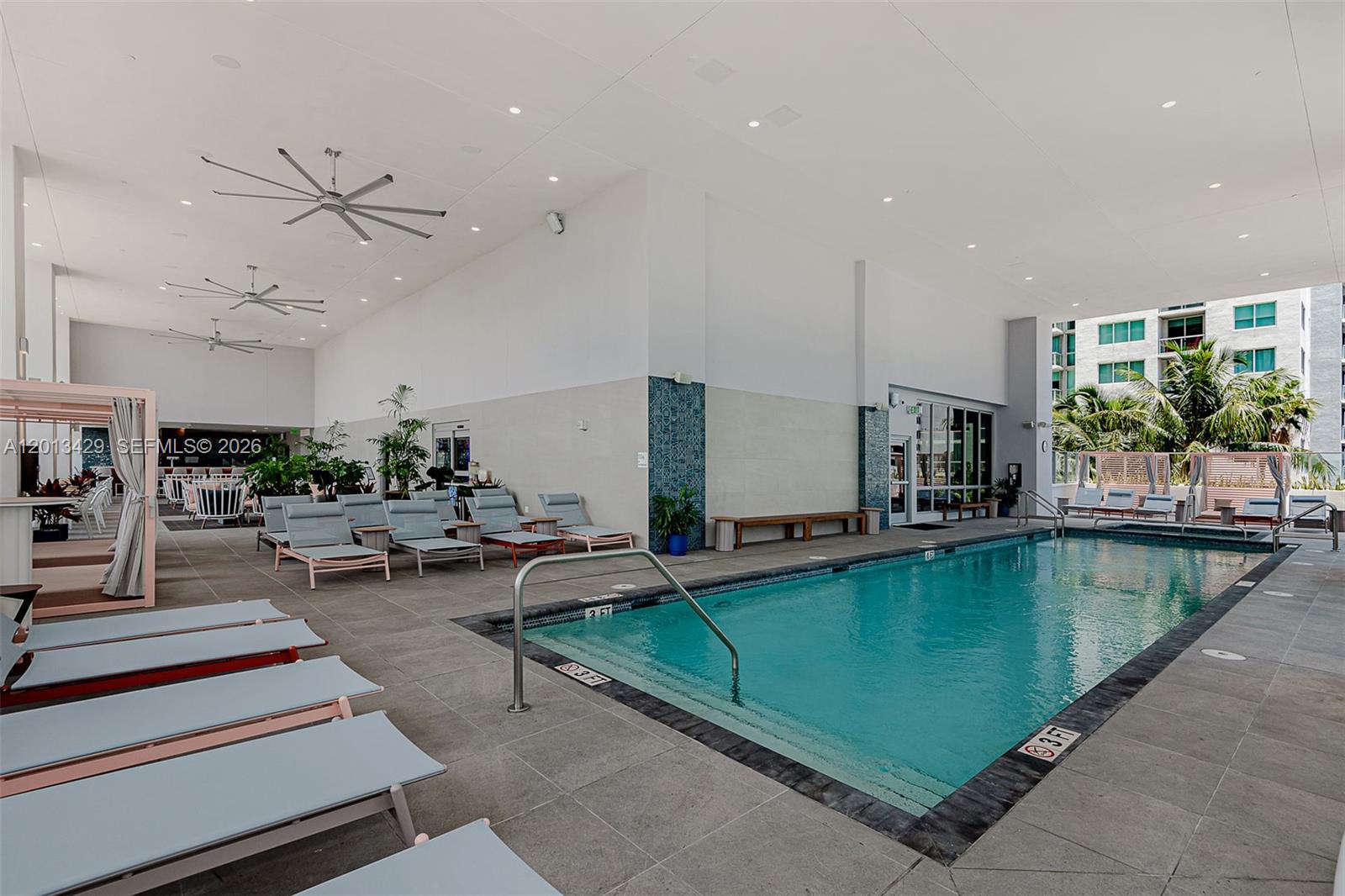 A covered swimming pool area features lounge chairs, ceiling fans, and tiled flooring — 227 NE 2nd St # 2206, Miami FL 33132, MIAMI, FL