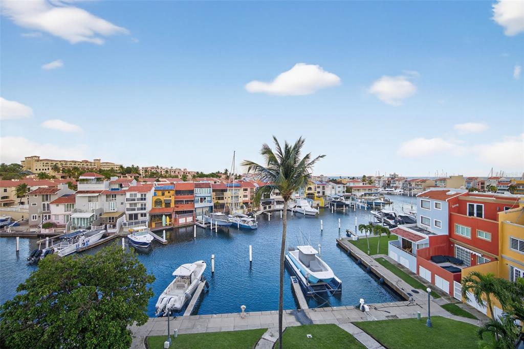 An elevated view of a marina with docked boats surrounded by colorful waterfront townhouses — 50 PENINSULA DE SAN JUAN, HUMACAO, PR