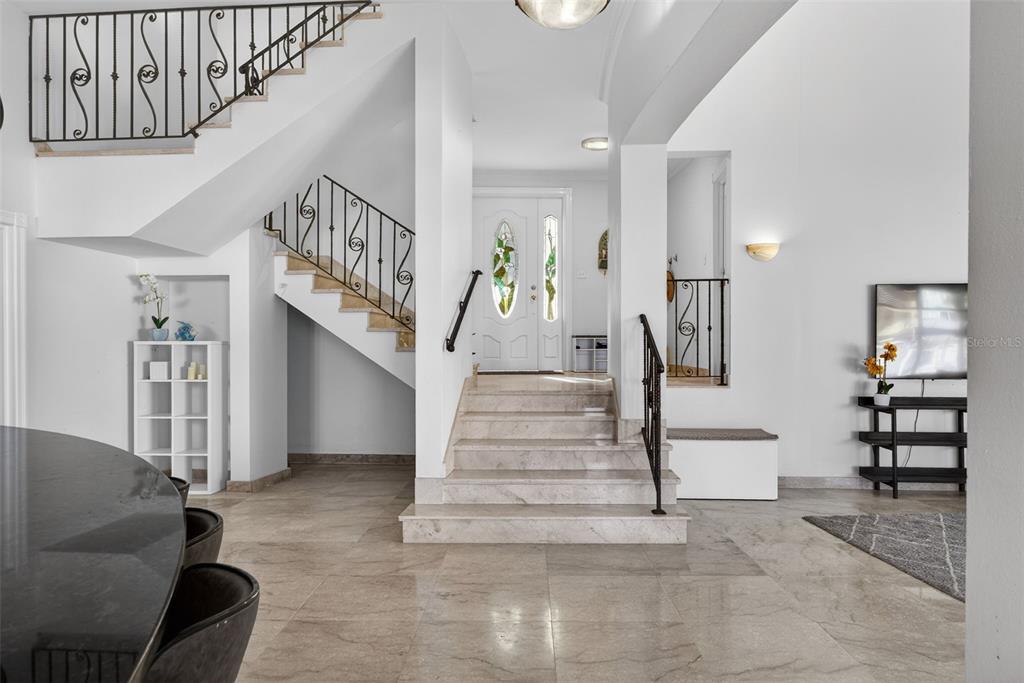 A foyer features marble flooring, a central staircase, and a white front door with glass — 50 PENINSULA DE SAN JUAN, HUMACAO, PR