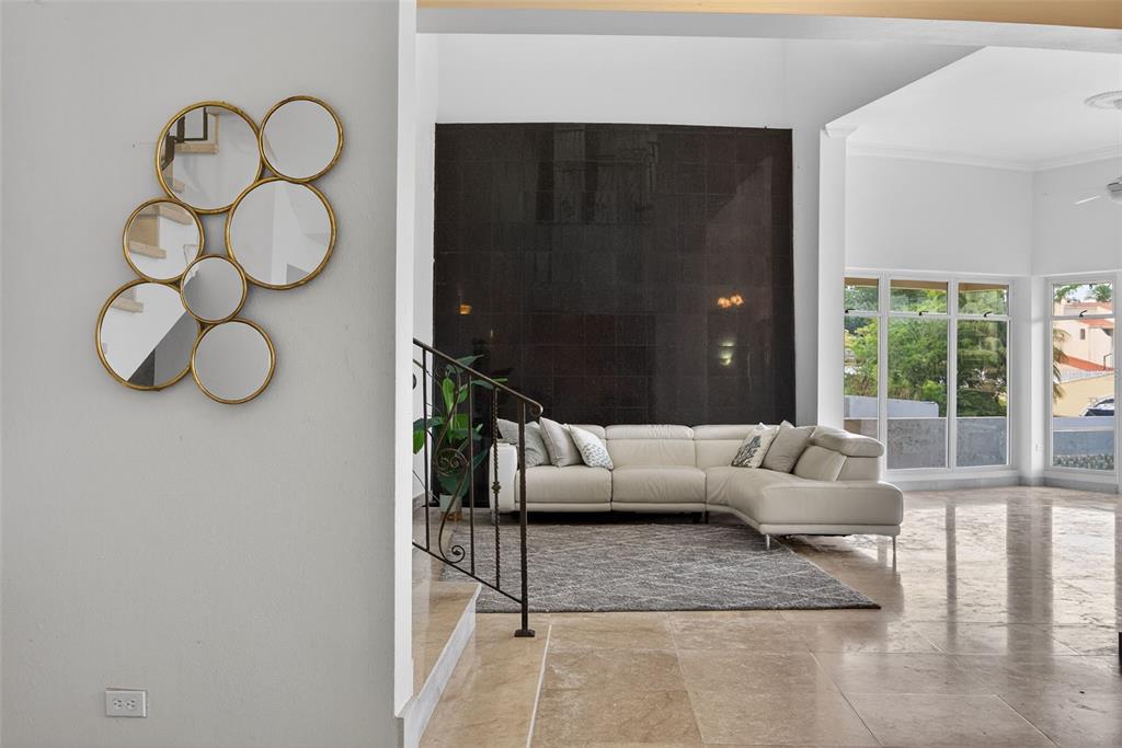 A living room features a large black tiled wall, a white sectional sofa, and mirrors — 50 PENINSULA DE SAN JUAN, HUMACAO, PR