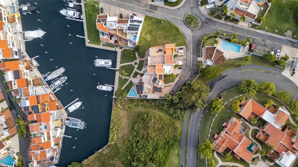 An aerial view shows waterfront townhomes with boat slips, private pools, and solar panels — 50 PENINSULA DE SAN JUAN, HUMACAO, PR