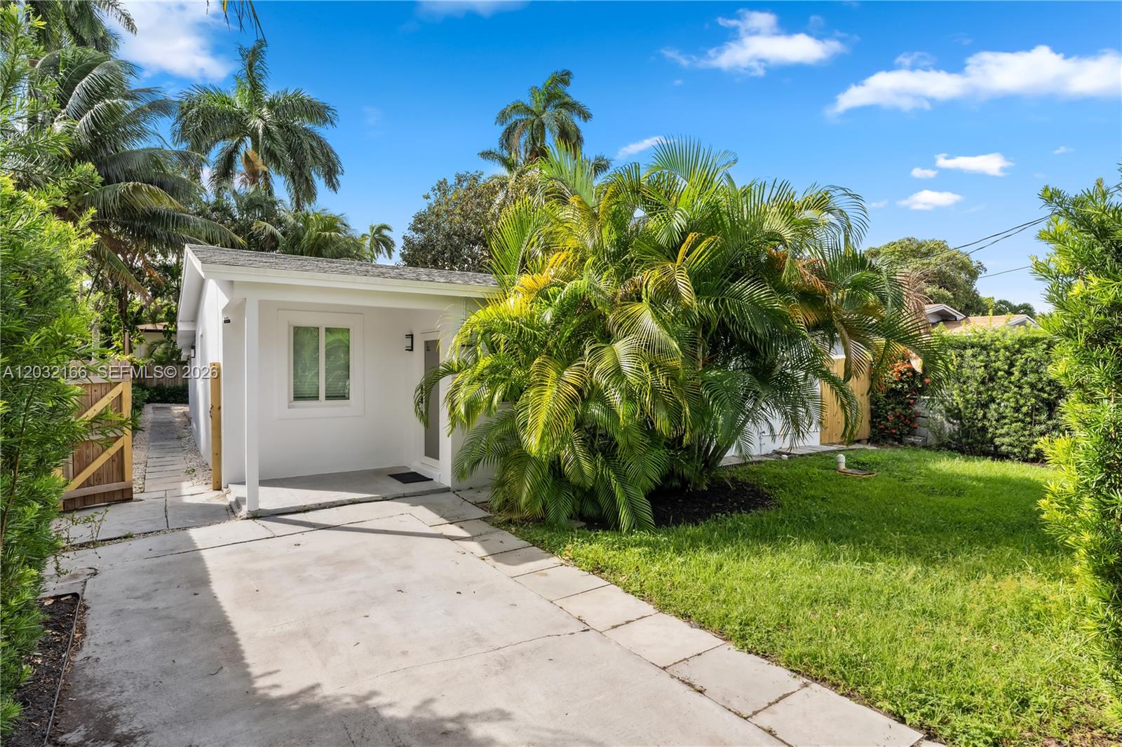 A small white house with a concrete driveway and palm trees in the front yard — 1480 NE 117th St # 1480, Miami FL 33161, MIAMI, FL
