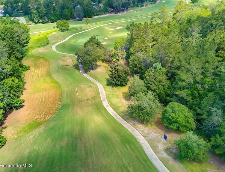 An aerial view shows a golf course fairway winding through a wooded area — 5947 CREEK RIDGE ROAD, BROOKSVILLE, FL