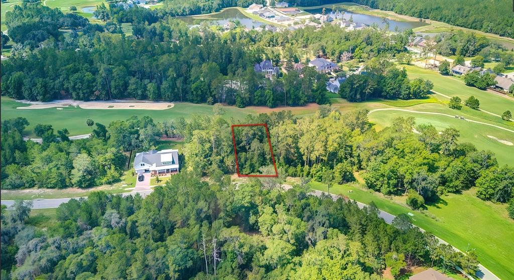 An aerial view shows a vacant, wooded residential lot outlined in red next to a house — 5947 CREEK RIDGE ROAD, BROOKSVILLE, FL