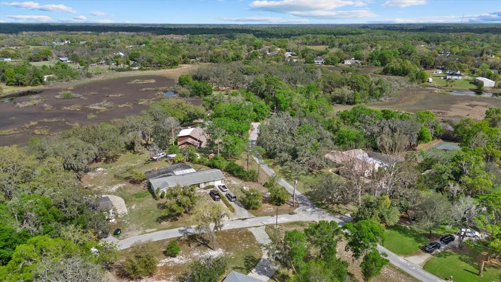 An aerial view shows a residential property with a house, driveway, and surrounding wooded landscape — INDALE DR, NEW PORT RICHEY, FL