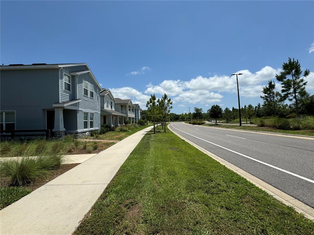 A sidewalk runs alongside a road next to a row of suburban houses — 13823 RANGELAND BOULEVARD, ODESSA, FL