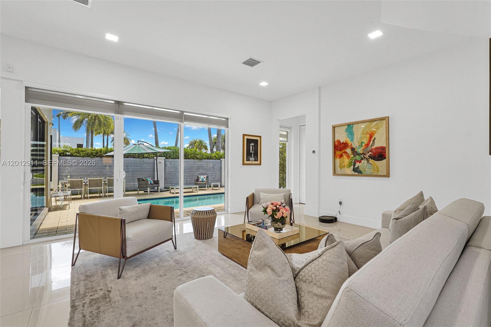 A bright living room features a large sliding glass door opening to a private pool area — 7509 NW 99th Ave, Doral FL 33178, DORAL, FL