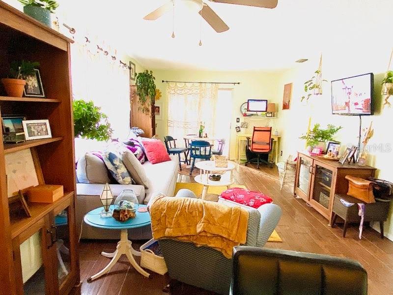 A living room features a sofa, an armchair, a wooden bookshelf, and a television — 6438 71ST STREET N, PINELLAS PARK, FL