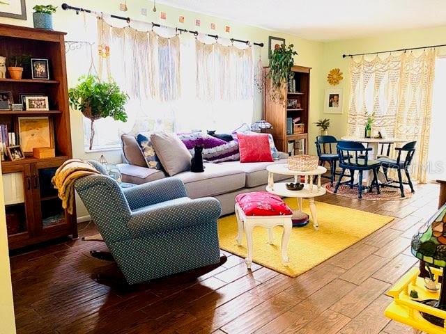 A living room features a grey sofa, a blue armchair, and a yellow area rug — 6438 71ST STREET N, PINELLAS PARK, FL
