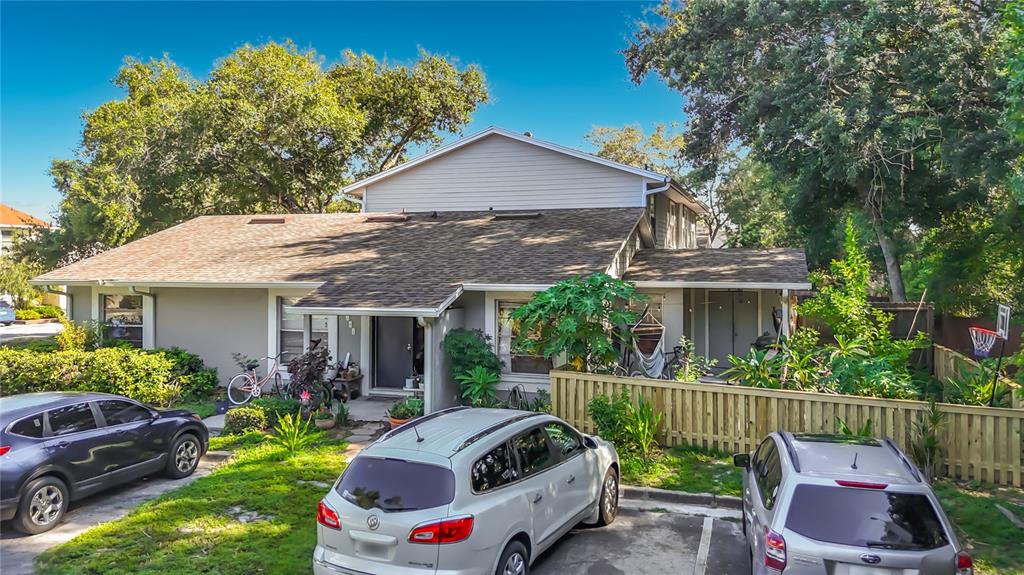 A two-story house with a gray exterior, a shingled roof, and three cars parked in front — 15101 MORNING DR, LUTZ, FL