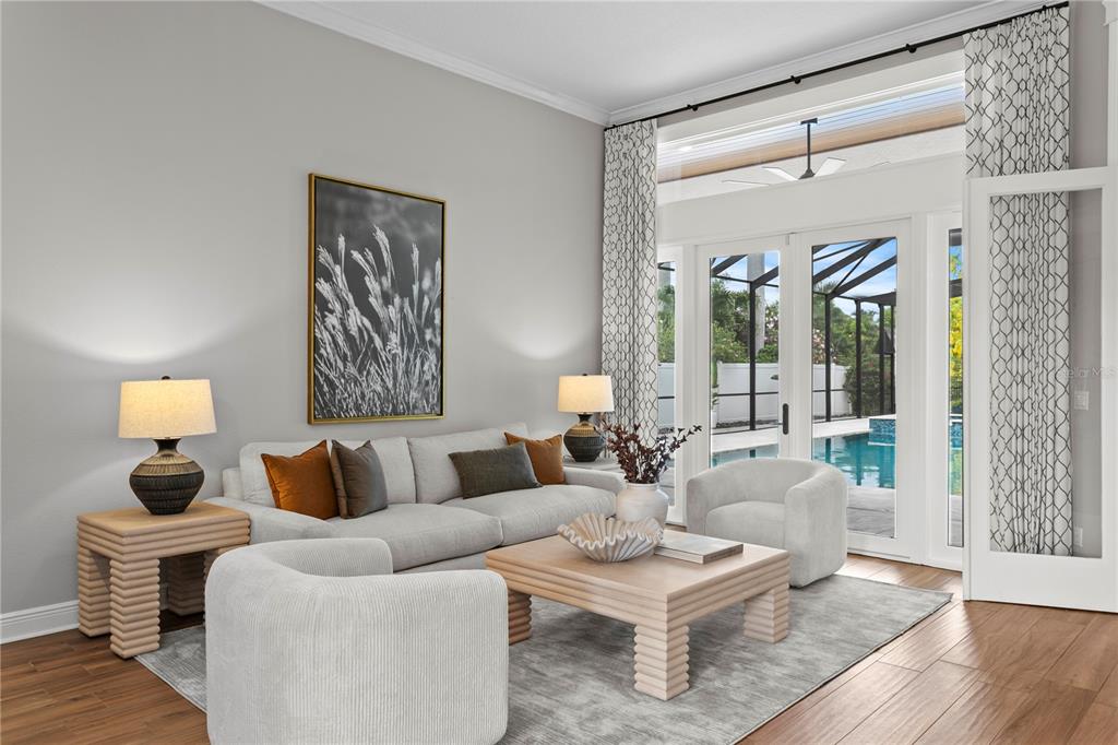 A living room features a light gray sofa, two armchairs, and a view of a pool — 1230 DARLINGTON OAK CIRCLE NE, ST PETERSBURG, FL