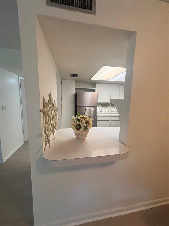 A kitchen pass-through window with a countertop and a decorative starfish wall display — 628 FAIRWAYS CIRCLE UNIT B, OCALA, FL