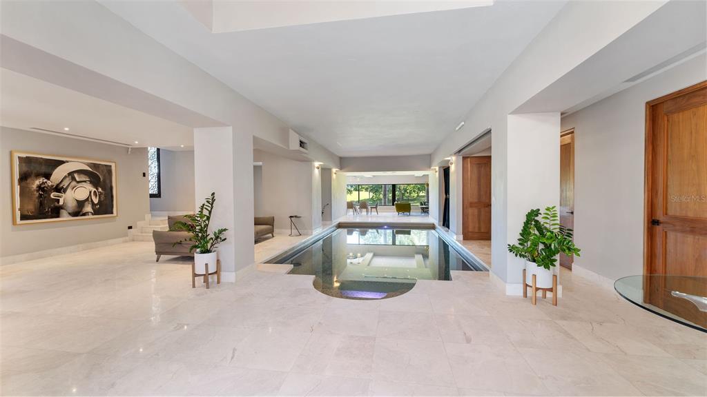 An indoor swimming pool is centered in a spacious room with light tile flooring — #13 Quintas del Deportivo CARR 102 KM 14.3 SECTOR JOYUDA, BO. MIRADERO, CABO ROJO, PR