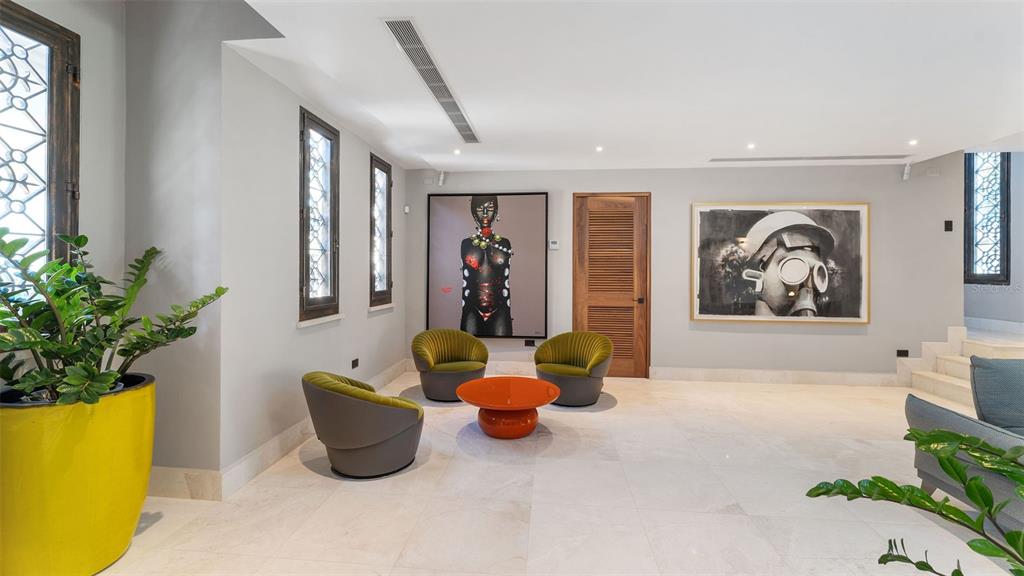 A modern living area features three green chairs, an orange coffee table, and two large paintings — #13 Quintas del Deportivo CARR 102 KM 14.3 SECTOR JOYUDA, BO. MIRADERO, CABO ROJO, PR