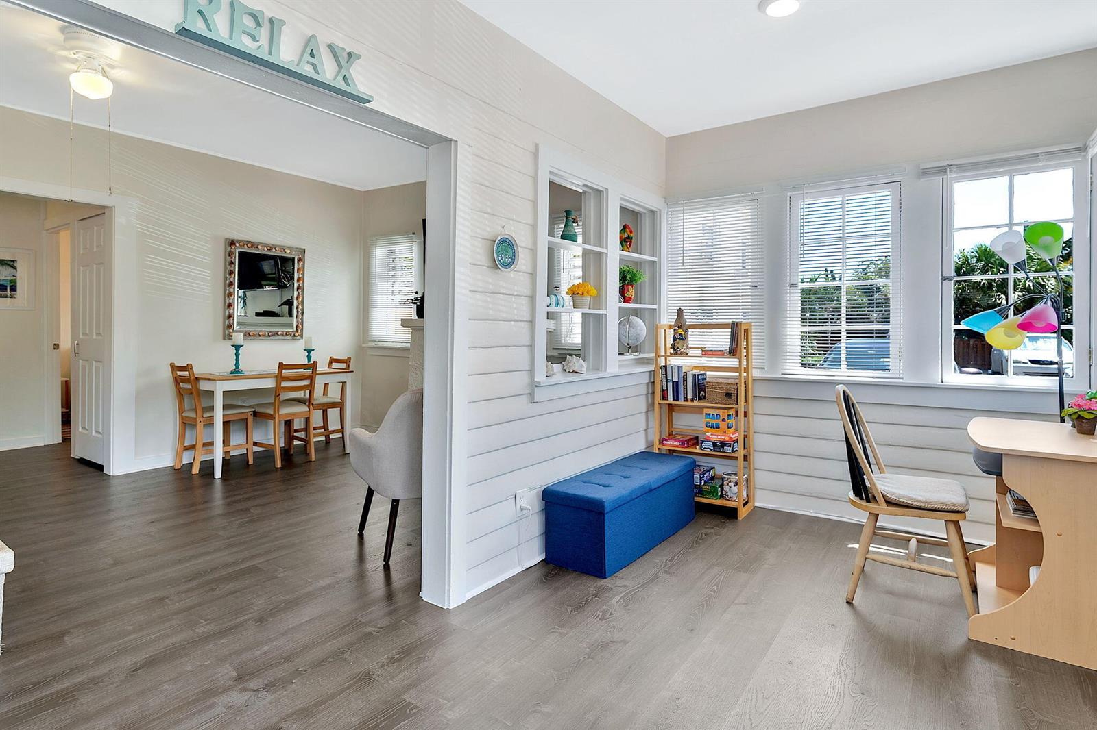 A sunroom features wood-look flooring, a blue storage bench, a bookshelf, and a dining area — 118 S J Street, FL 33460, FL