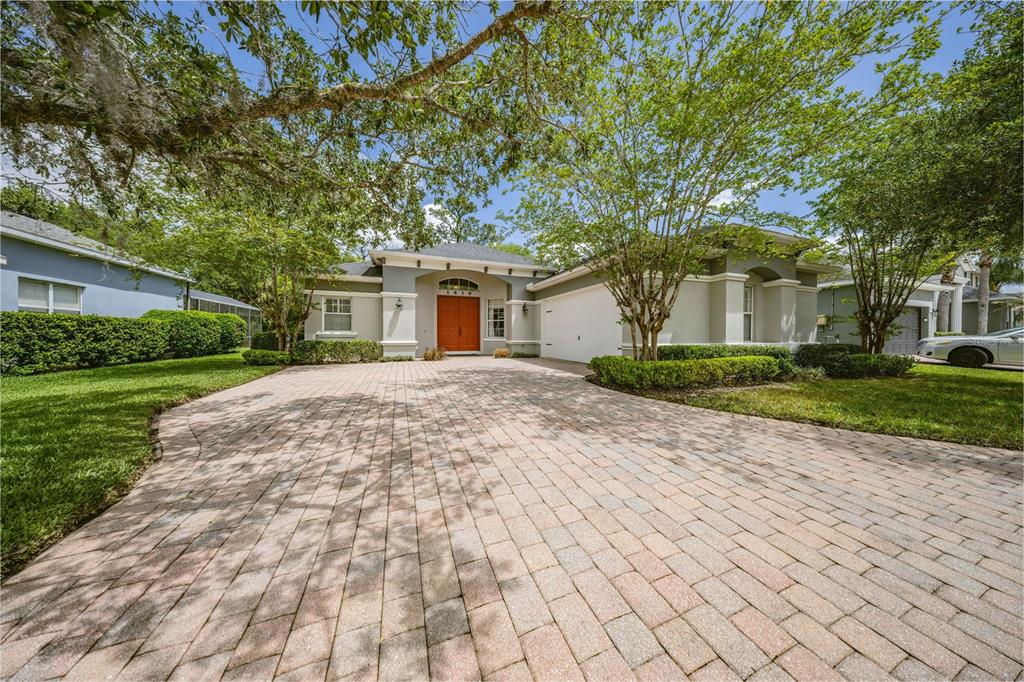 A single-story house with a paved driveway, a two-car garage, and a bright orange front door — 1619 STARGAZER TERRACE, SANFORD, FL