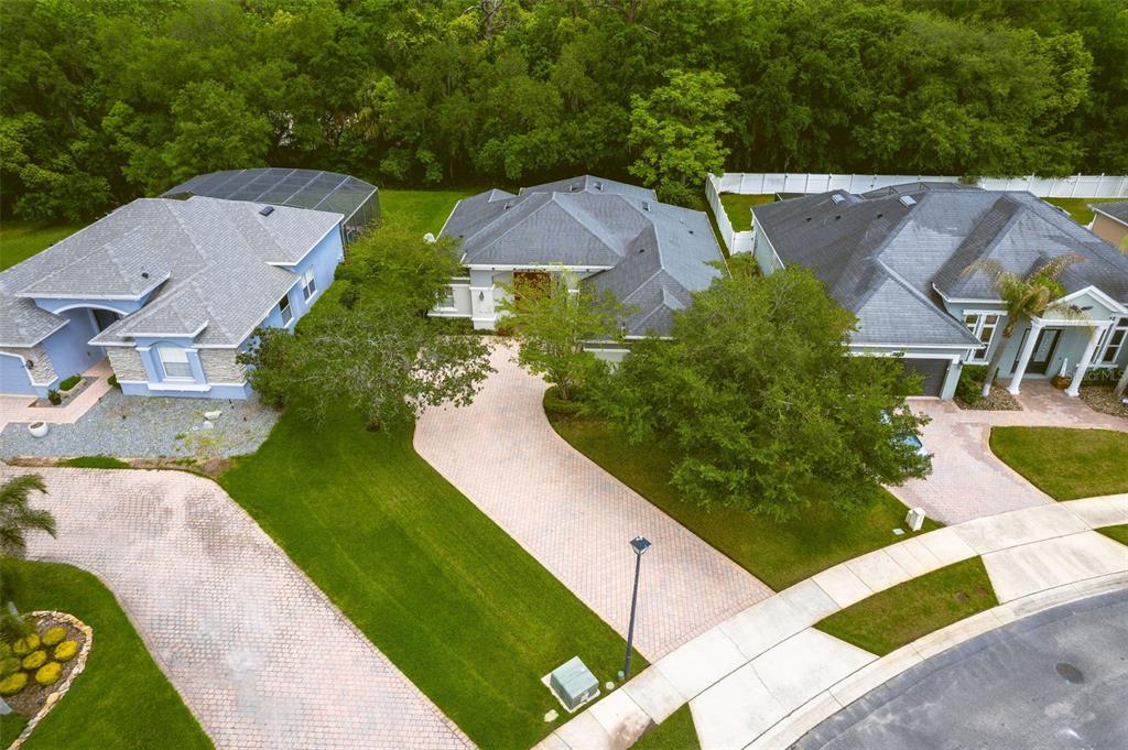 An aerial view shows three suburban houses with paved driveways and green lawns — 1619 STARGAZER TERRACE, SANFORD, FL