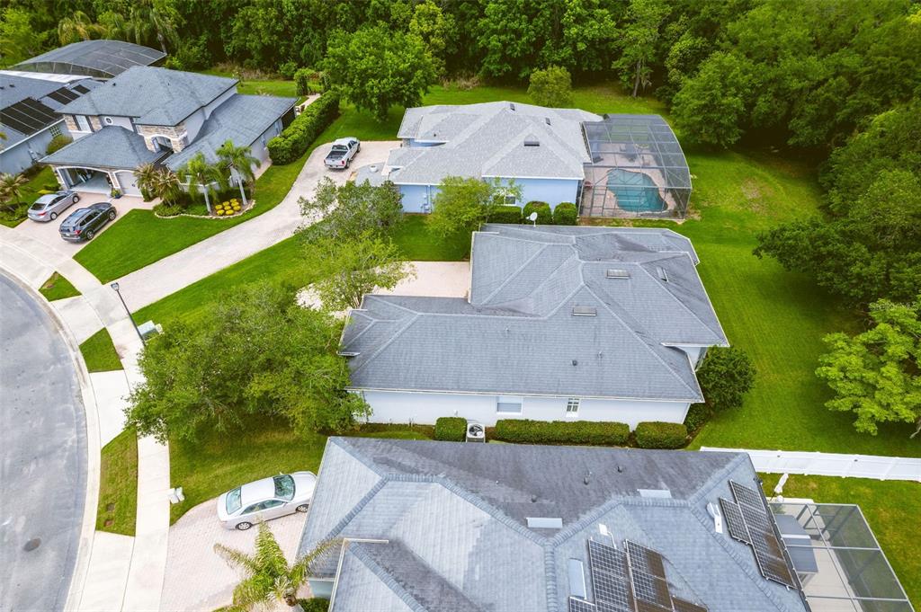An aerial view shows several suburban houses with driveways, lawns, and backyard swimming pools — 1619 STARGAZER TERRACE, SANFORD, FL