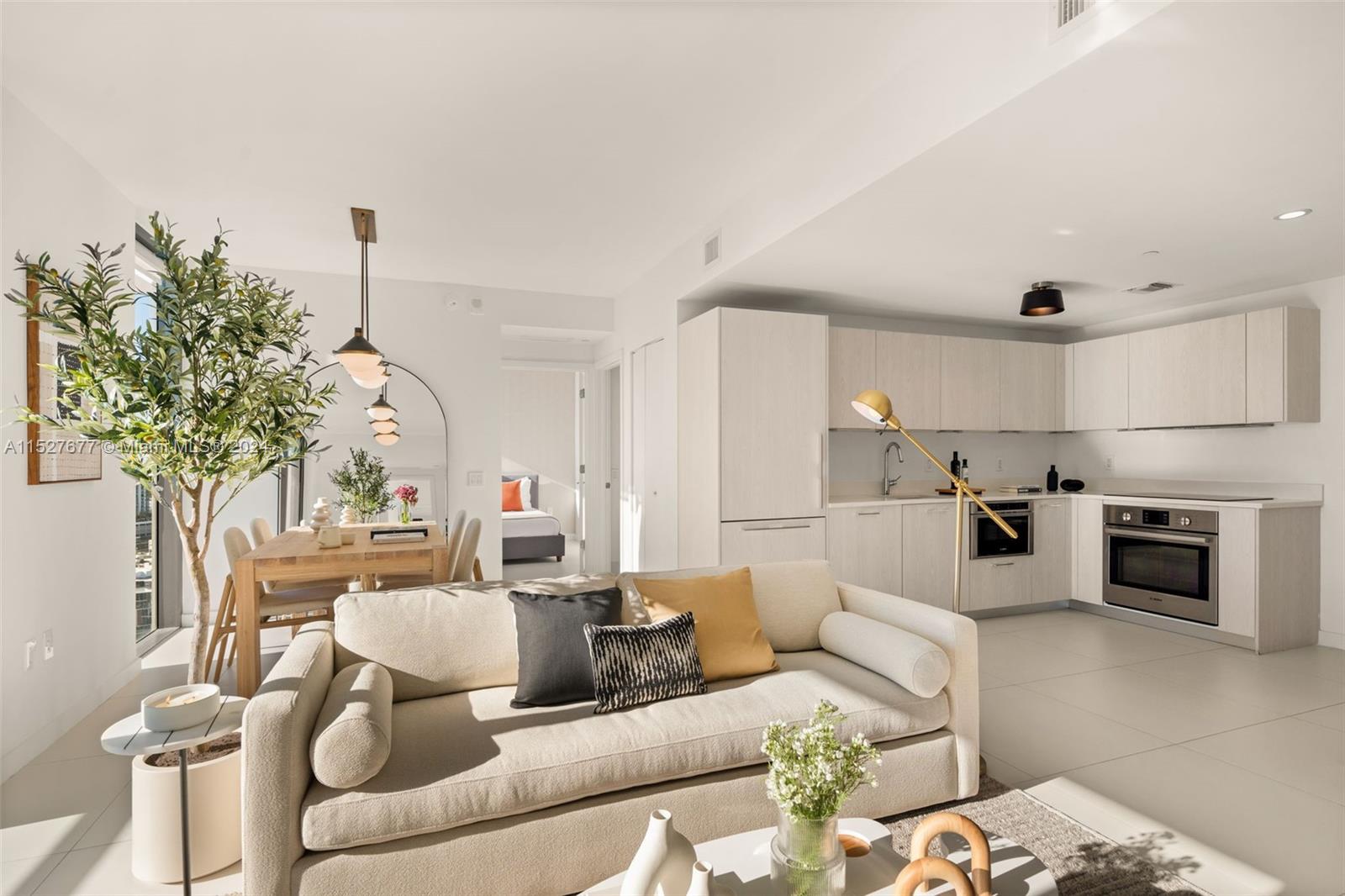 A modern open-concept living room and kitchen featuring light wood cabinetry and neutral furniture — 501 NE 31st St # 2209, Miami FL 33137, MIAMI, FL