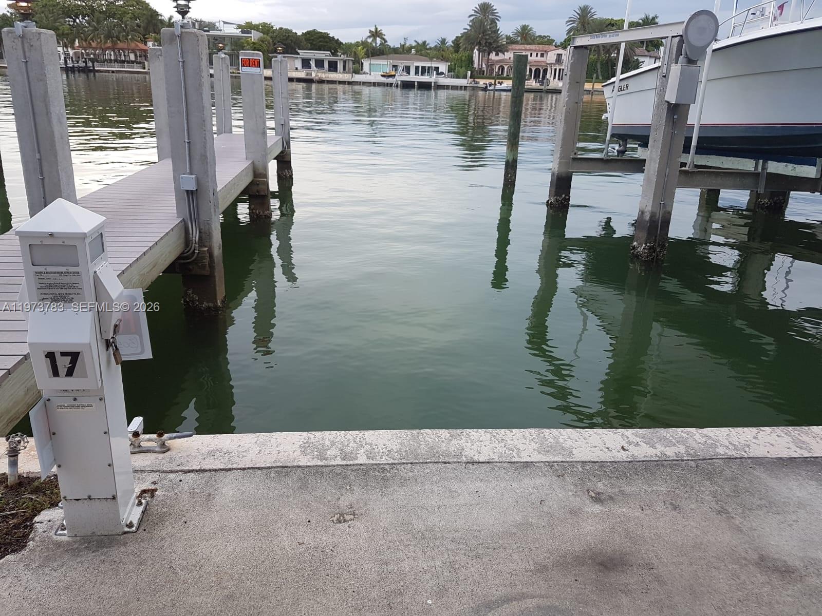 A concrete dock features a boat lift and a numbered utility pedestal overlooking the water — 5401 Collins Ave #13-17, Miami Beach FL 33140, MIAMI BEACH, FL