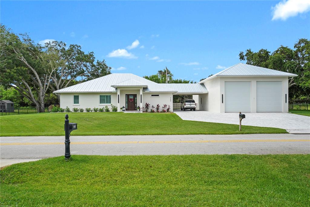 A single-story house with a metal roof, attached garage, and a large front lawn — 4255 79TH STREET, VERO BEACH, FL
