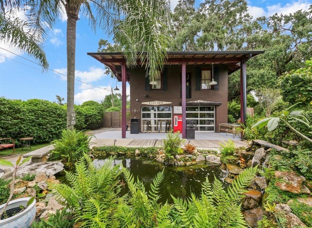 A two-story brown building with a ground-floor kitchen and a pond in the foreground — 4421 EDGEWATER DRIVE, ORLANDO, FL