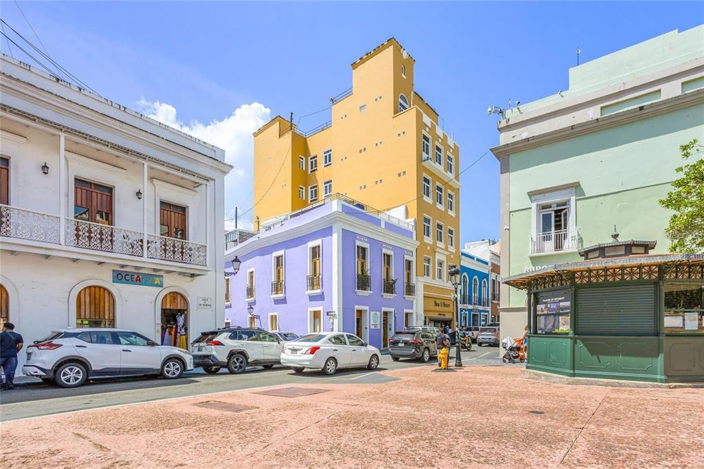 A street view of a plaza featuring colorful historic buildings and parked cars in San Juan — 266 SAN FRANCISCO UNIT 266, SAN JUAN, PR