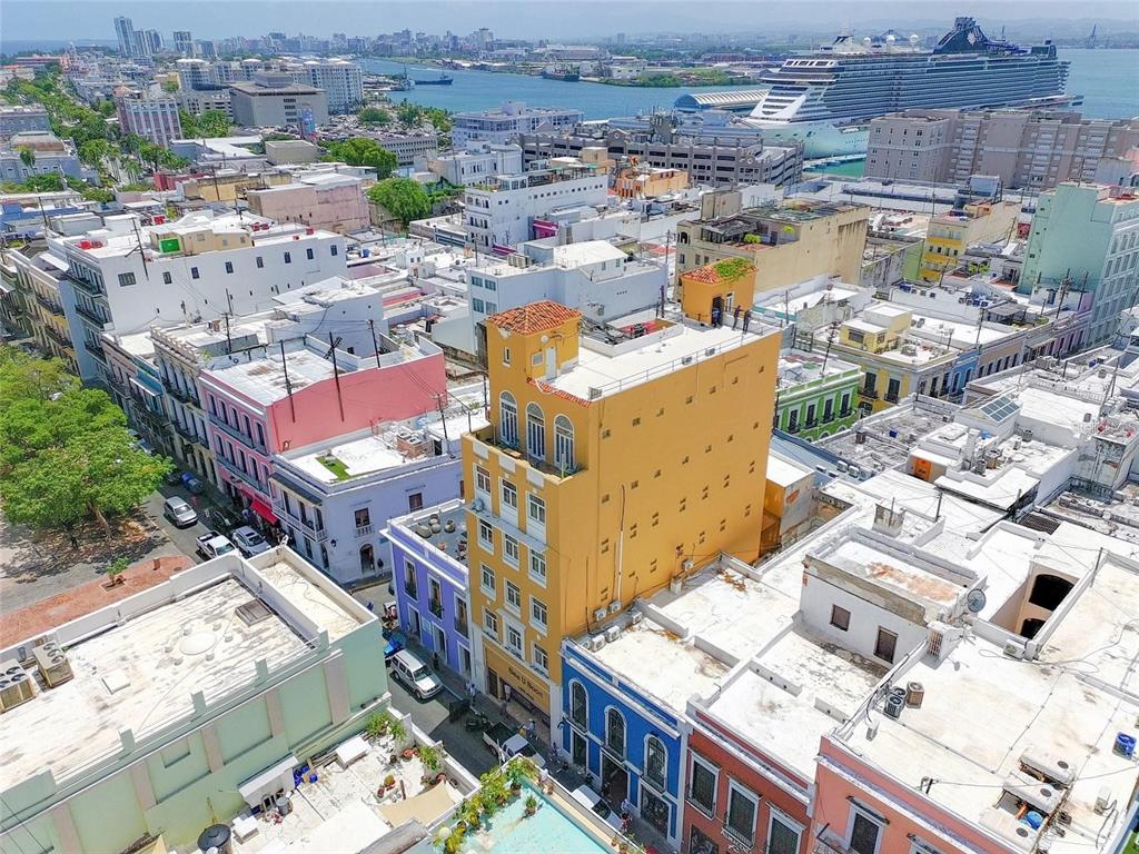An aerial view of a yellow building surrounded by other colorful structures and a harbor — 266 SAN FRANCISCO UNIT 266, SAN JUAN, PR