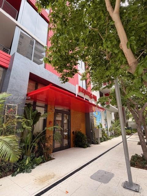 The exterior of a modern building features a prominent red awning over the entrance — 90 NE 32nd St # 823, Miami FL 33137, MIAMI, FL