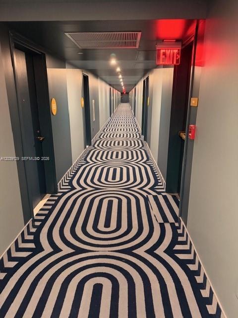 A long hotel hallway features a geometric blue and white patterned carpet and dark doors — 90 NE 32nd St # 823, Miami FL 33137, MIAMI, FL