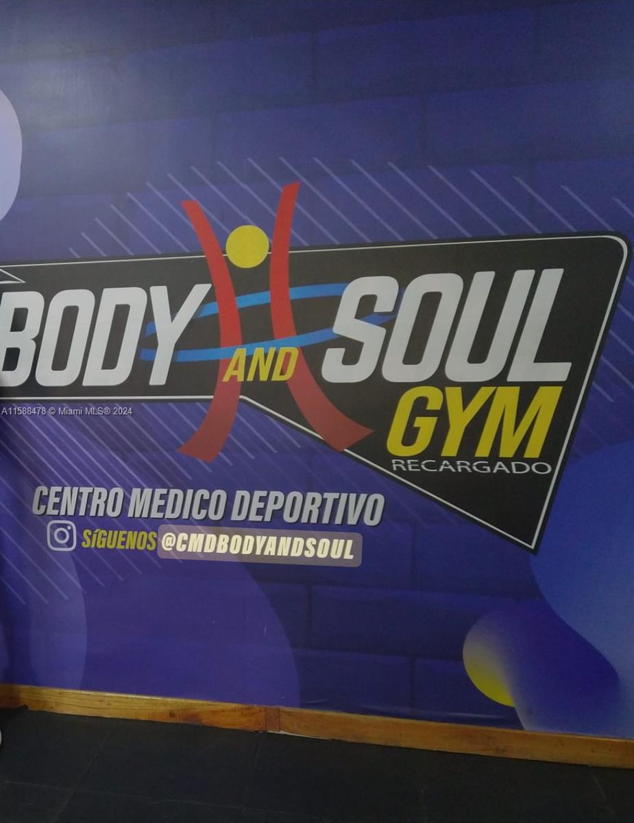 A wall features a large logo for Body and Soul Gym with social media information — Carrera 64 85-53, 00000, FL