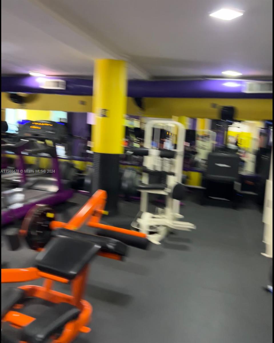 This gym features various exercise machines, a bright yellow support column, and purple ceiling accents — Carrera 64 85-53, 00000, FL