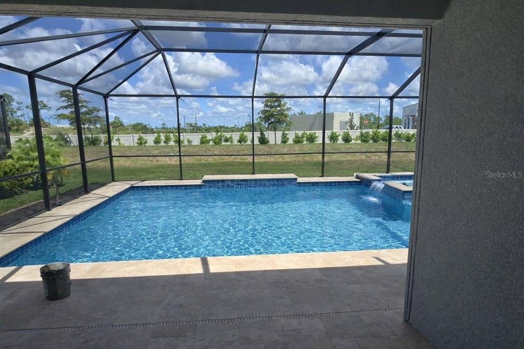 A screened-in patio overlooks a rectangular swimming pool with a spillover spa — 11399 PINOT DRIVE, VENICE, FL