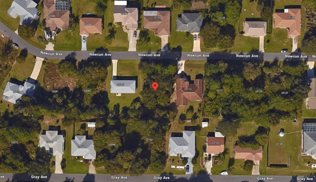This satellite map shows a vacant residential lot situated between two houses on a street — 23105 NEWCUN AVENUE, PUNTA GORDA, FL