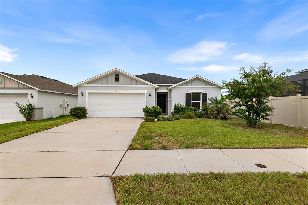 This open-concept living room features a large sectional sofa, two armchairs, and a kitchen island — 1425 ENGELBERG STREET, WINTER HAVEN, FL