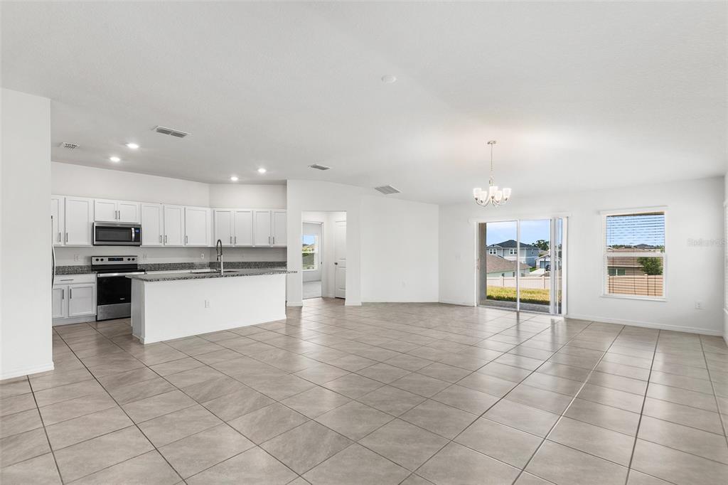 A kitchen with white cabinets, granite countertops, a center island, and stainless steel appliances — 1425 ENGELBERG STREET, WINTER HAVEN, FL