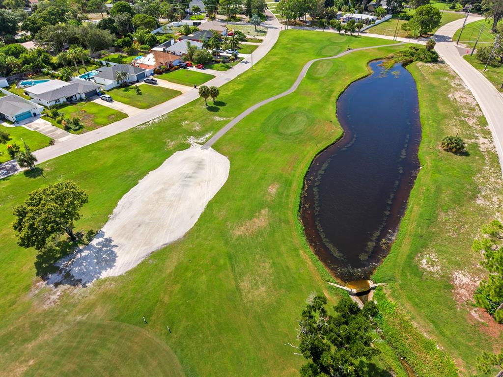 An aerial view of a golf course fairway with a sand bunker and a large pond — 2159 BARCELONA WAY, ST PETERSBURG, FL