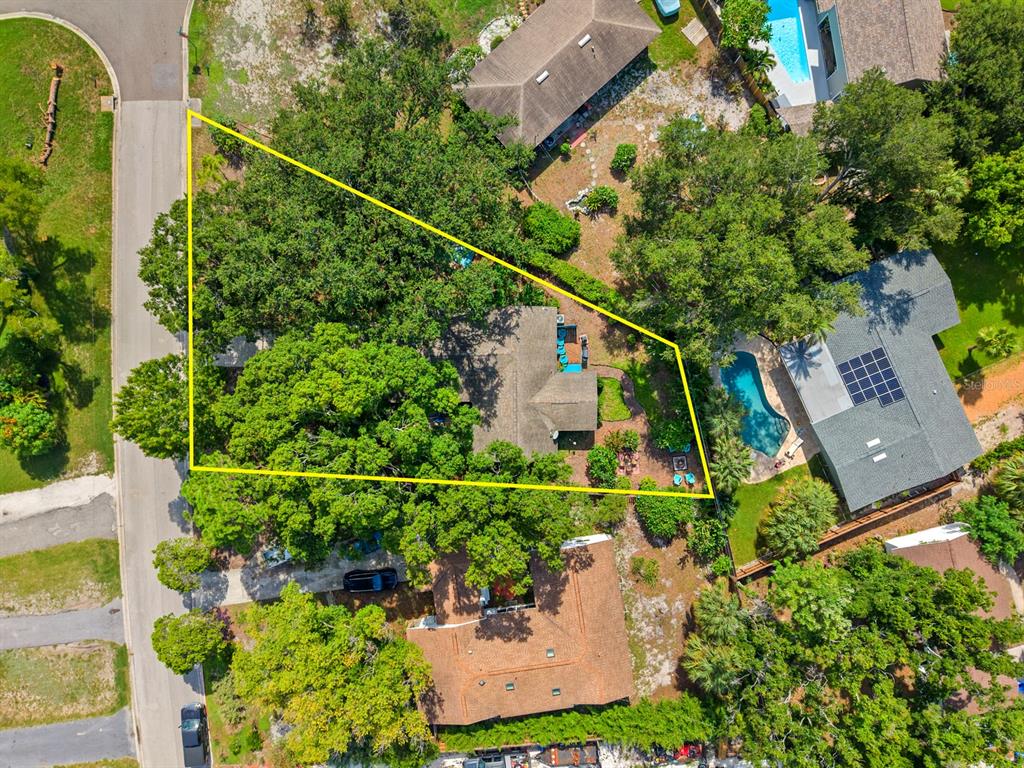 An aerial view shows a residential property with a house, pool, and large trees — 2159 BARCELONA WAY, ST PETERSBURG, FL