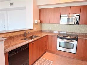 A kitchen features wood cabinets, granite countertops, stainless steel appliances, and a tile backsplash — 700 E Boynton Beach Boulevard # 510, Boynton Beach FL 33435, BOYNTON BEACH, FL