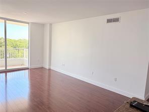 An empty living room with hardwood floors, white walls, and a sliding glass balcony door — 700 E Boynton Beach Boulevard # 510, Boynton Beach FL 33435, BOYNTON BEACH, FL