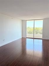 An empty room with dark wood flooring, white walls, and a sliding glass balcony door — 700 E Boynton Beach Boulevard # 510, Boynton Beach FL 33435, BOYNTON BEACH, FL