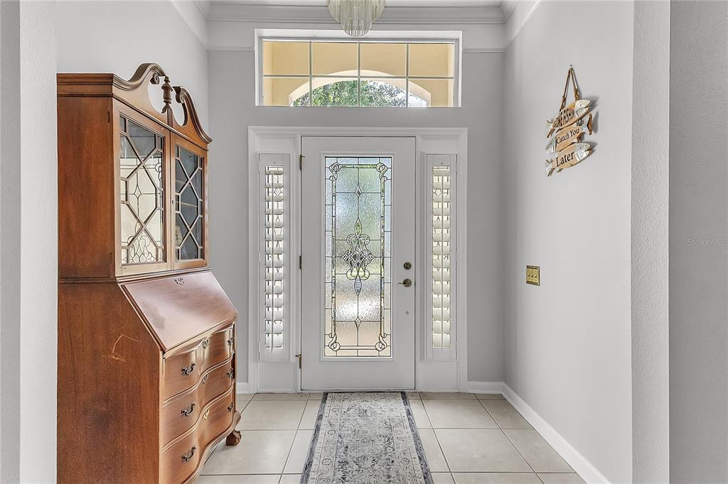 An entryway features a wooden secretary desk, a white front door with glass, and tile flooring — 32 SHINNECOCK DRIVE, PALM COAST, FL
