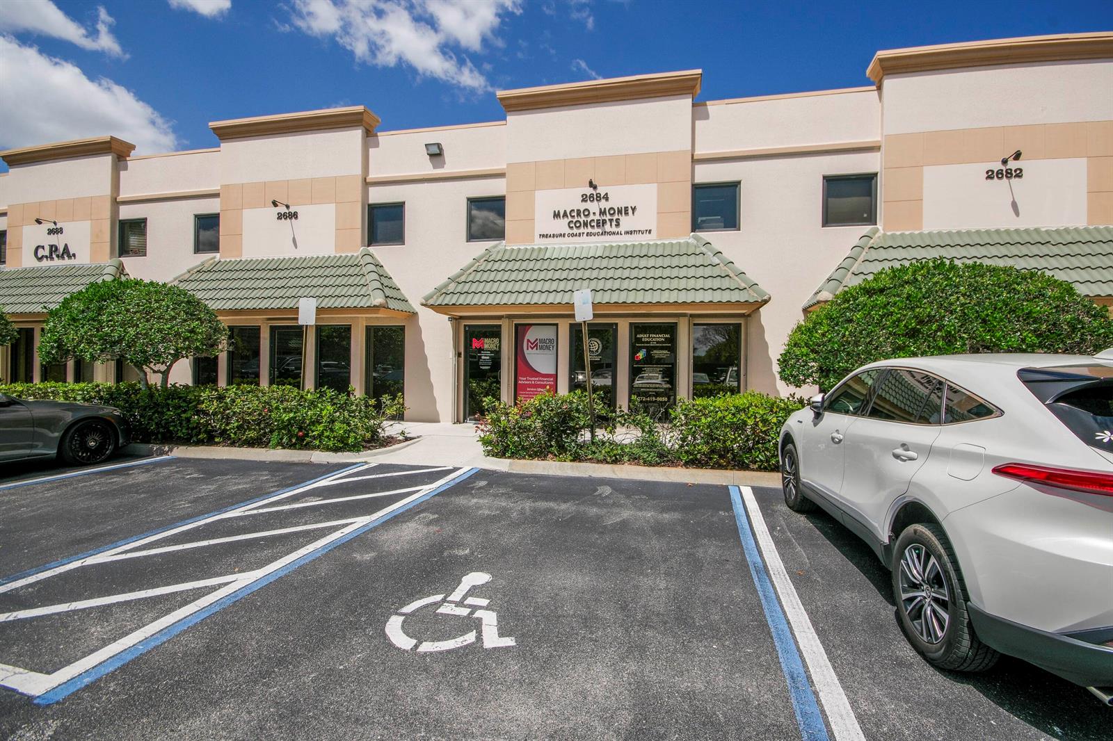 A low-rise commercial building exterior features a central entrance with a green tiled awning — 2684 SE Willoughby Boulevard, Stuart FL 34994, STUART, FL