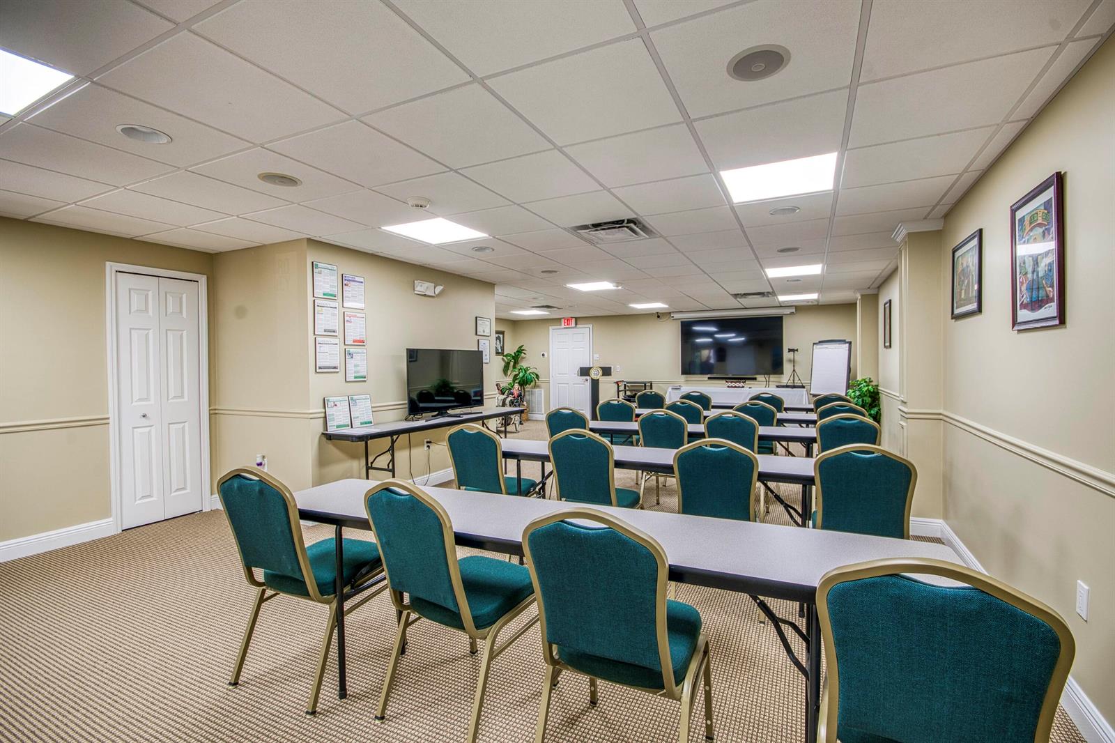 A conference room features rows of chairs facing a television screen and a white board — 2684 SE Willoughby Boulevard, Stuart FL 34994, STUART, FL