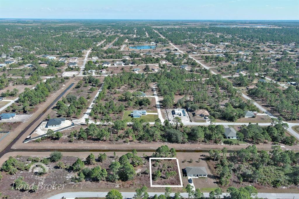 An aerial view shows a vacant lot outlined in white within a rural residential area — 943 FOXDALE AVENUE, LEHIGH ACRES, FL