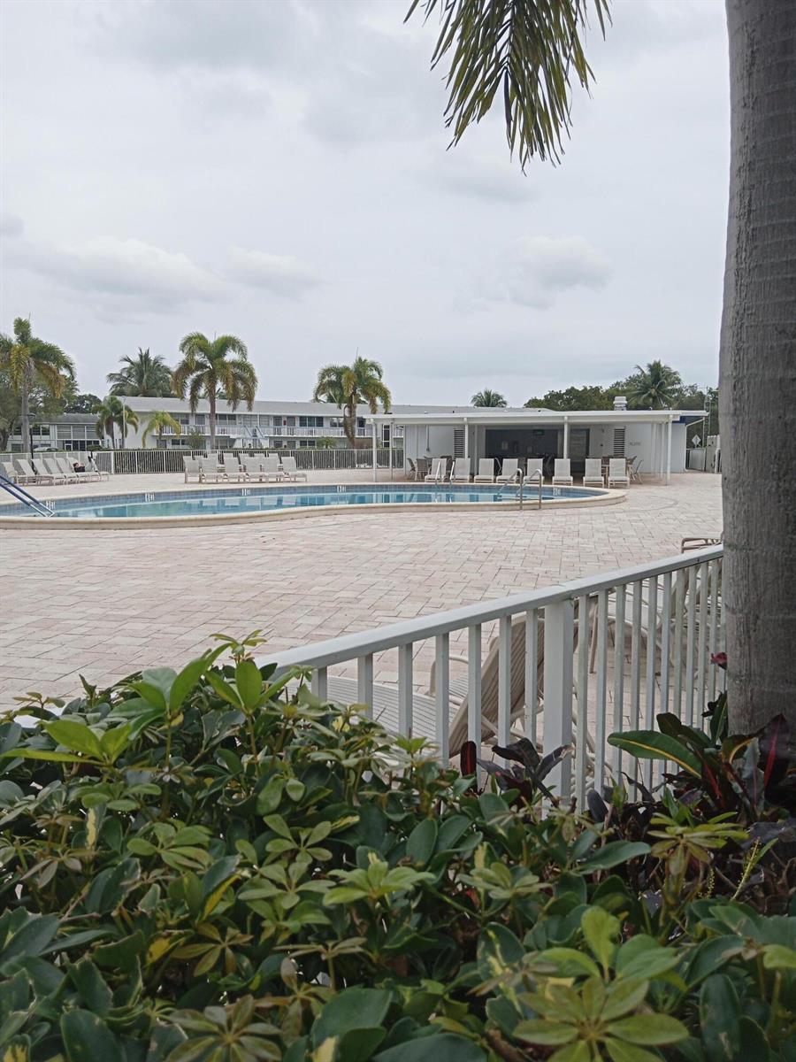A swimming pool with a surrounding patio and a covered outdoor seating area — 302 Markham N # 302, Deerfield Beach FL 33442, DEERFIELD BEACH, FL